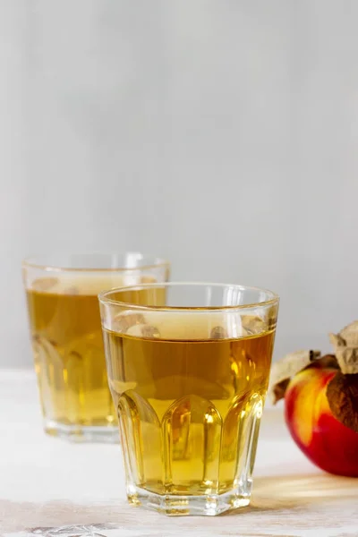 Appelsap in glazen en verse appels op een houten achtergrond. Rustieke stijl. — Stockfoto