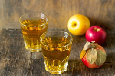 Gözlük ve ahşap arka plan üzerinde taze elma elma suyu. Rustik tarzı.