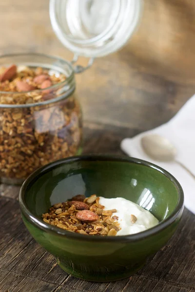 Useful breakfast is yoghurt with granola. Granola with yoghurt in a ceramic bowl and granola in a glass. — Stock Photo, Image