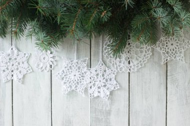 Çam dalları ve beyaz zemin üzerine örme beyaz kar taneleri ile Noel ve yeni yıl arka plan.