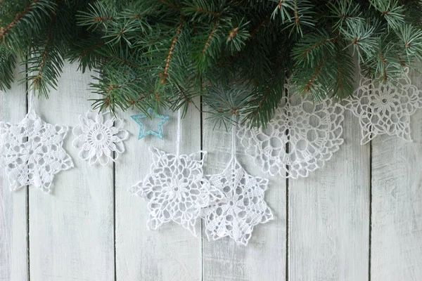 Kerstmis of Nieuwjaar achtergrond met spar takken en gebreide witte sneeuwvlokken op een witte achtergrond. — Stockfoto
