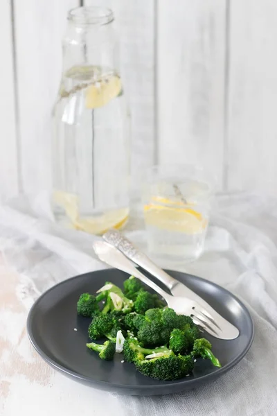 Broccoli cooked with garlic, ginger and sesame served with lemonade. Rustic style. — Stock Photo, Image
