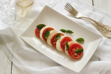Caprese salatası olgun domates ve mozzarella peyniri taze fesleğen yaprakları ile. Italyan Mutfagi.