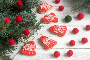 Gingerbread çan, çelenk soluk boncuk ve hafif bir arka plan - Ladin dallarında bir Noel ve yeni yıl kartı.