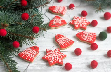 Gingerbread çan, yıldız, fötr boncuk ve açık renkli Noel dallarda köknar veya yeni yıl kartı çelenk.
