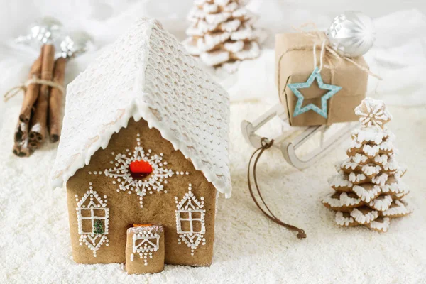 Gingerbread house and gingerbread tree on a light background.