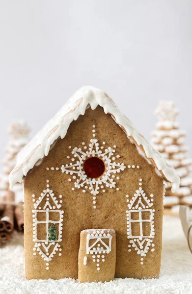 Gingerbread house and gingerbread tree on a light background.