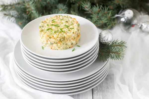 Традиционный праздничный салат Оливье на белой тарелке с новогодним или рождественским декором. Советские традиции . — стоковое фото