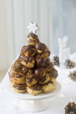 Çam kozalakları ve bir geyik figürü çelenk ile Noel ve yeni yıl dekorasyonda Croquembusch pasta.