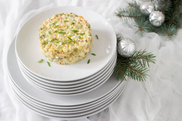 Традиционный праздничный салат Оливье на белой тарелке с новогодним или рождественским декором. Советские традиции . — стоковое фото