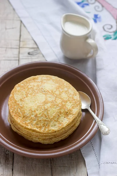 Pilha de panquecas russas com nata azeda - blini em uma chapa na mesa de madeira . — Fotografia de Stock