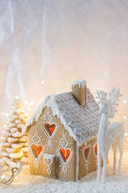 Gingerbread house, Noel ağaçları ve bir geyik parlak bir arka plan üzerinde bir rakam. Bokeh etkisi.