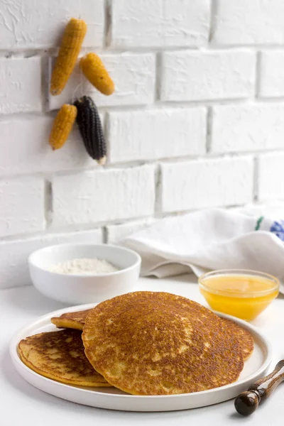 Coconut corn pancakes with honey. Rustic style.