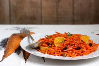 Sulu vitamini havuç salatası portakal, Kuru erik ve fındık. Rustik tarzı.