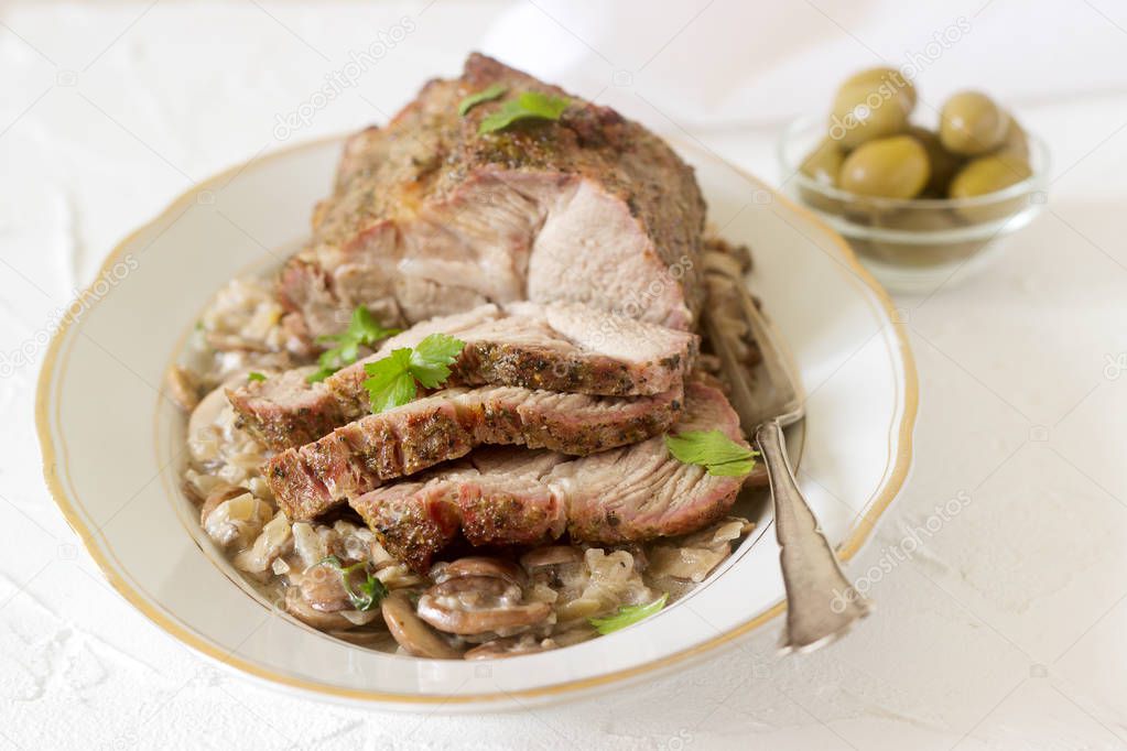Juicy appetizing boiled pork with mushroom sauce. Rustic style.
