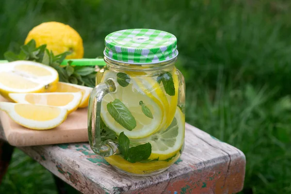 Hausgemachte Limonade mit Minze und Eis auf einer Holzbank im Garten. rustikaler Stil. — Stockfoto