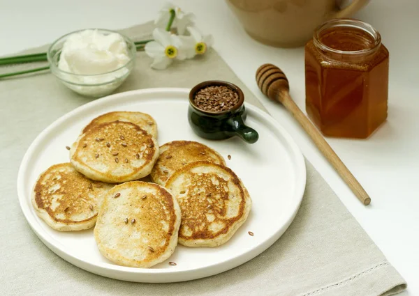 Panqueques de lino servidos con miel y queso crema sobre un fondo claro. Estilo rústico . — Foto de Stock