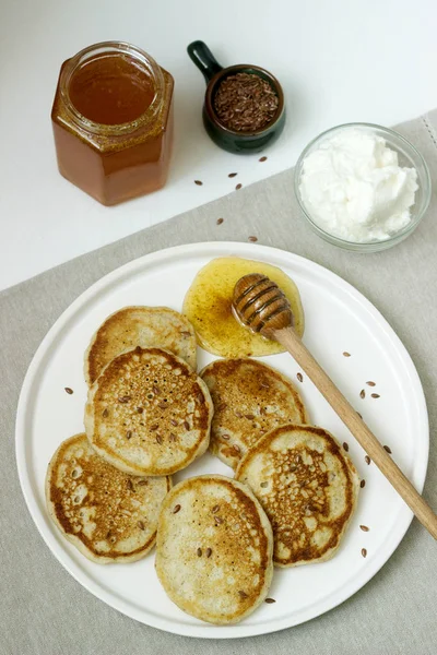 Leinenpfannkuchen mit Honig und Frischkäse auf hellem Hintergrund. rustikaler Stil. — Stockfoto