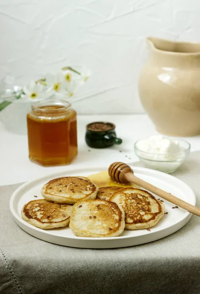 Panqueques de lino servidos con miel y queso crema sobre un fondo claro. Estilo rústico . — Foto de Stock