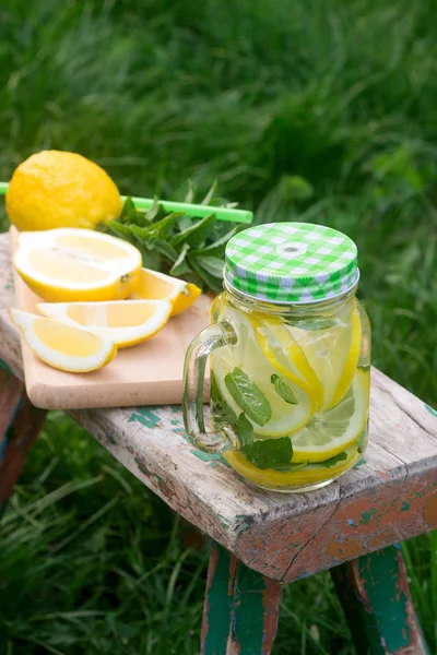 Hausgemachte Limonade mit Minze und Eis auf einer Holzbank im Garten. rustikaler Stil. — Stockfoto