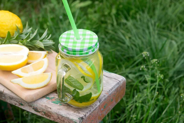 Hausgemachte Limonade mit Minze und Eis auf einer Holzbank im Garten. rustikaler Stil. — Stockfoto