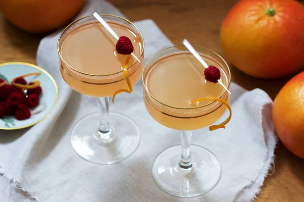 Cocktail champagne au jus de pamplemousse, garni de zeste et de framboises. Style rustique . — Photo