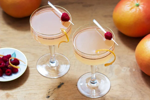 グレープフルーツジュースとシャンパンカクテル,ゼストとラズベリーを添え.素朴な様式. — ストック写真