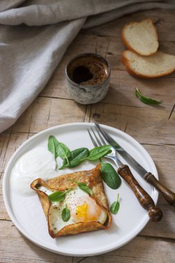 Breton karabuğday krep yumurta, ıspanak ve krem, kahve ile eğe. Rustik tarzı.