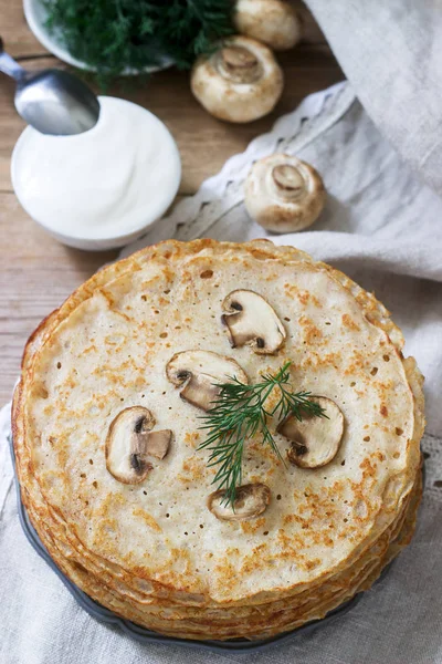 Buckwheat pancakes served with sour cream and dill on a wooden table. Rustic style. — Stock Photo, Image