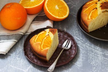 Beton zemin üzerinde portakal dilimleri olan turuncu pasta..