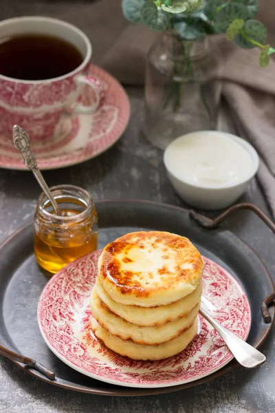 Quark-Pfannkuchen, hausgemachte Syrniki mit Honig und saurer Sahne. — Stockfoto