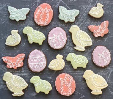 Easter gingerbread cookies decorated with various ornaments on a gray background. Selective focus.