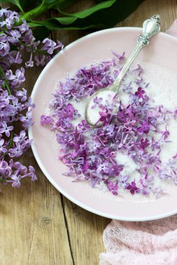 Ahşap arka planda leylak, leylak ve pembe peçeteli leylak çiçekleri. Kırsal biçim, seçici odak.