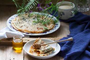 Isırgan otu ve ıspanaklı krep, bal ve kahve ile servis edilir. Kırsal biçim, seçici odak.
