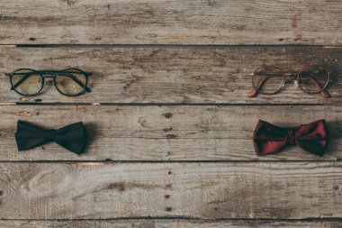 stylish bow ties and eyeglasses on tabletop clipart