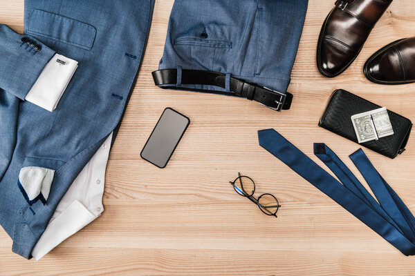 suit and accessories with smartphone on tabletop