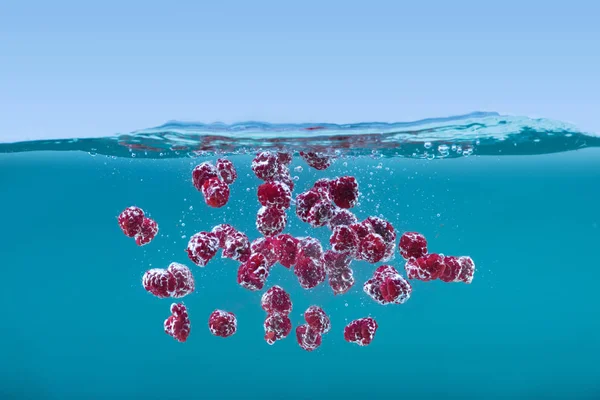 Ripe raspberries floating in water — Stock Photo, Image