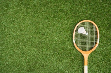 badminton racket with shuttlecock on grass clipart