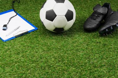 clipboard with soccer ball and boots on grass clipart