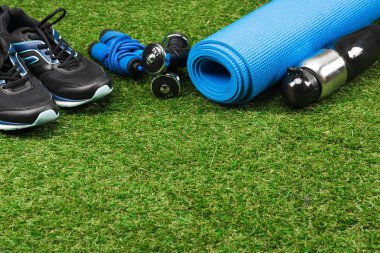 1 trainers with jump rope and dumbbells on grass clipart