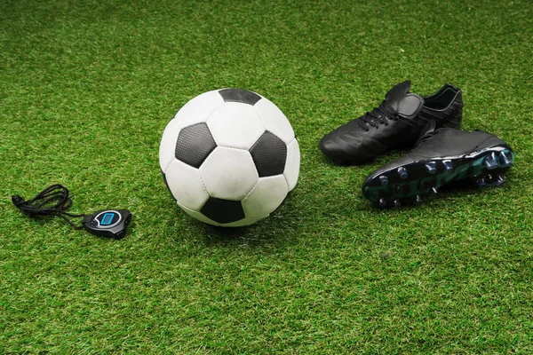 Stopwatch with soccer ball and boots on grass — Stock Photo, Image