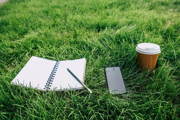 Notebook a digitální zařízení na trávě — Stock fotografie