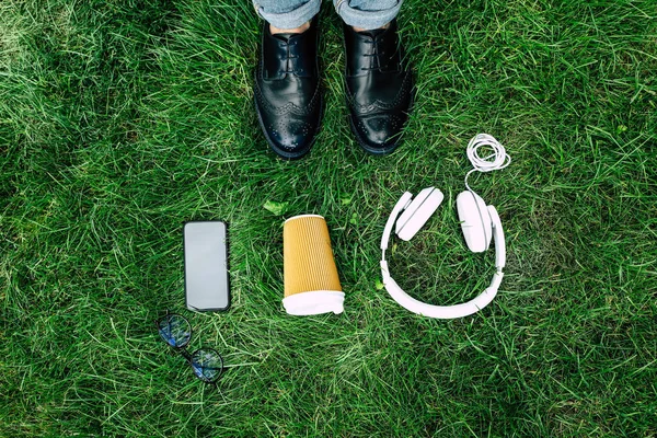 Digital devices and paper cup on grass — Free Stock Photo