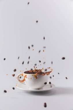 kahve fincanı düşen kahve taneleri ile