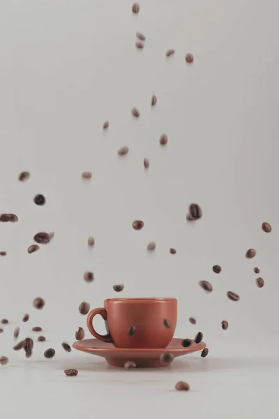 Taza de café con granos de café que caen — Foto de Stock