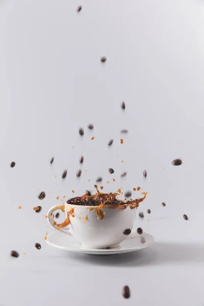 Kahve fincanı düşen kahve taneleri ile — Stok fotoğraf