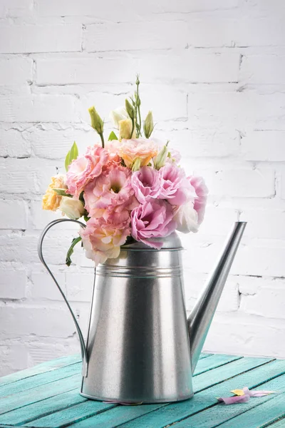 Beautiful flowers in watering can — Stock Photo, Image