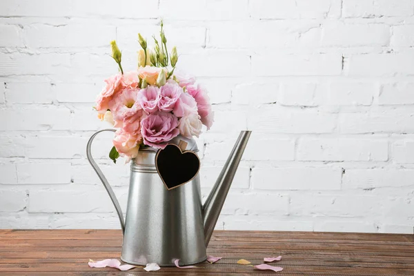 Beautiful flowers in watering can — Stock Photo, Image