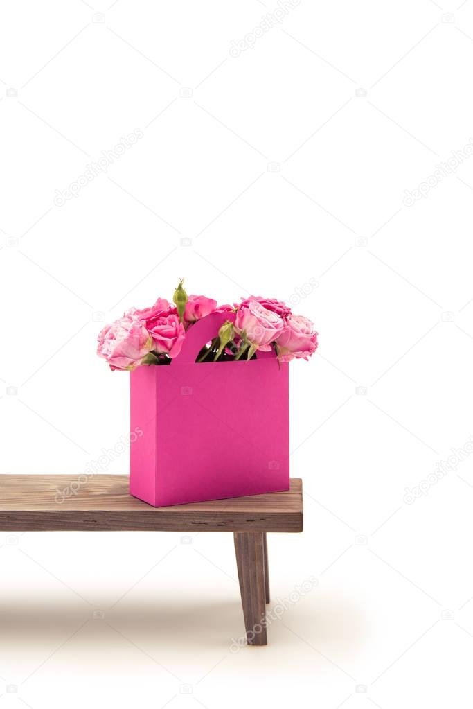 Roses in paper box on bench