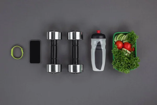 Dumbbells with vegetable salad and gadgets — Stock Photo, Image